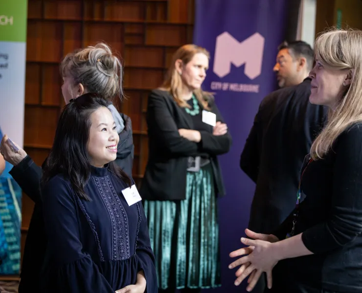 Two people at a corporate event talking to one another.